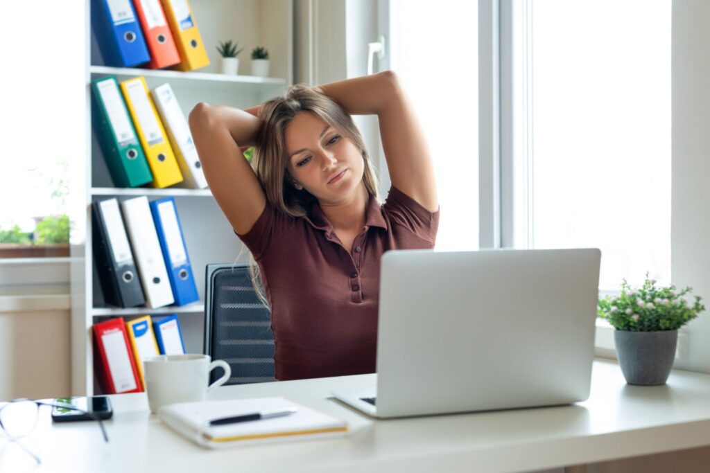 donna fa esercizi cervicali in pausa alla scrivania