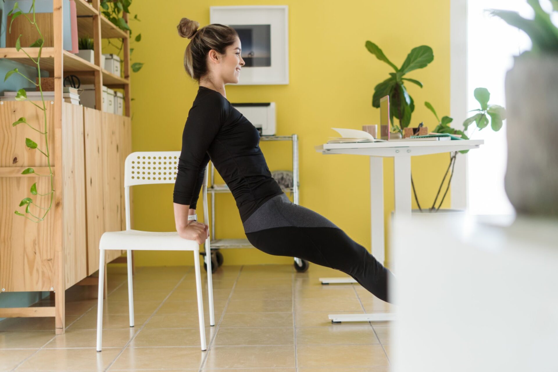 donna fa esercizi alla scrivania per allenarsi