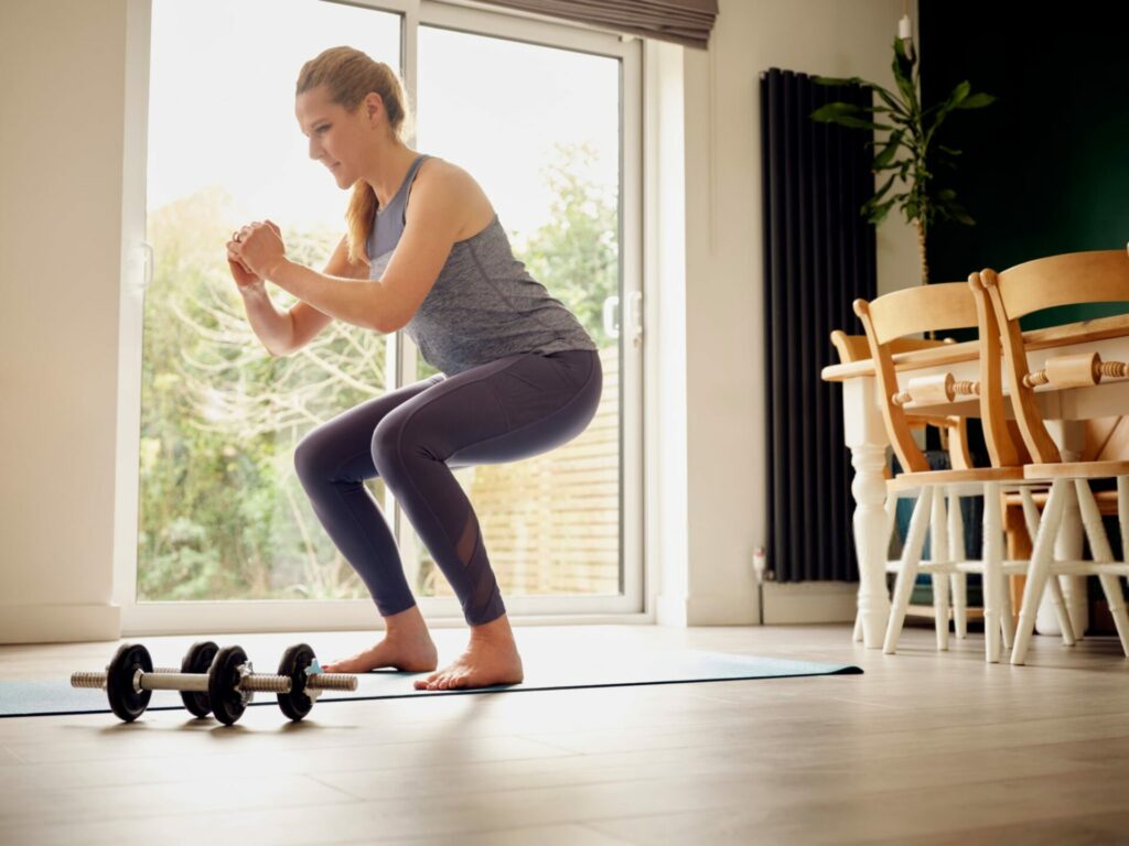 donna over 50 fa esercizi di squat a casa