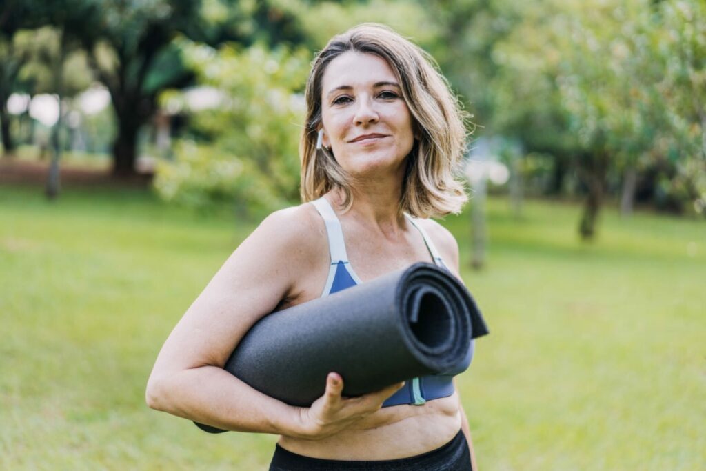 donna si prepara a fare yoga all'esterno